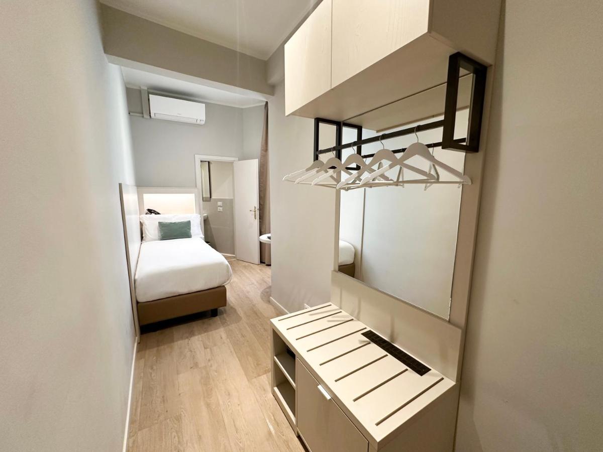 een slaapkamer met een bed en een bureau met een spiegel bij Hotel Giappone in Florence