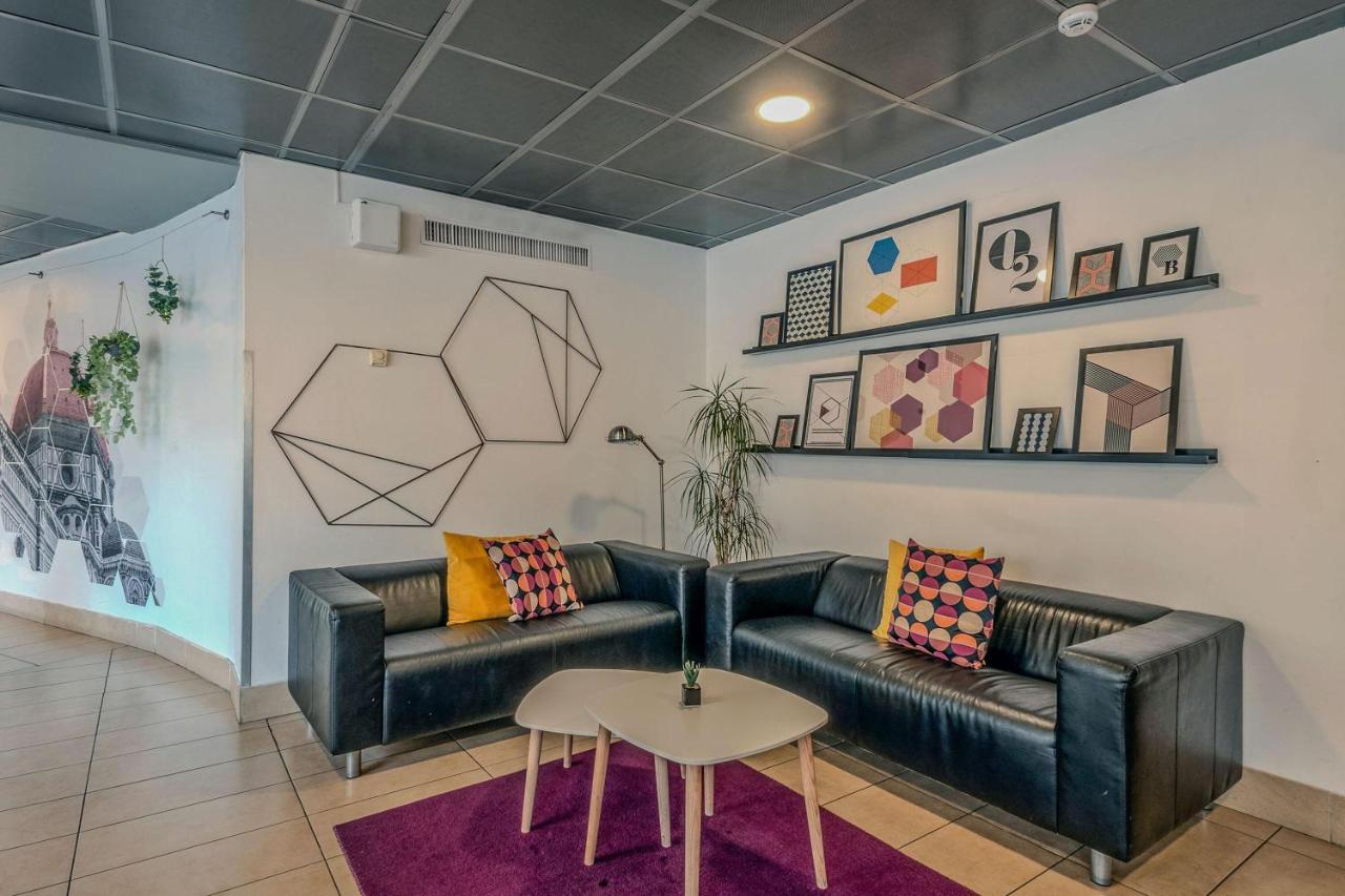 een woonkamer met een leren bank en een tafel bij B&B Hotel Firenze Nuovo Palazzo Di Giustizia in Florence