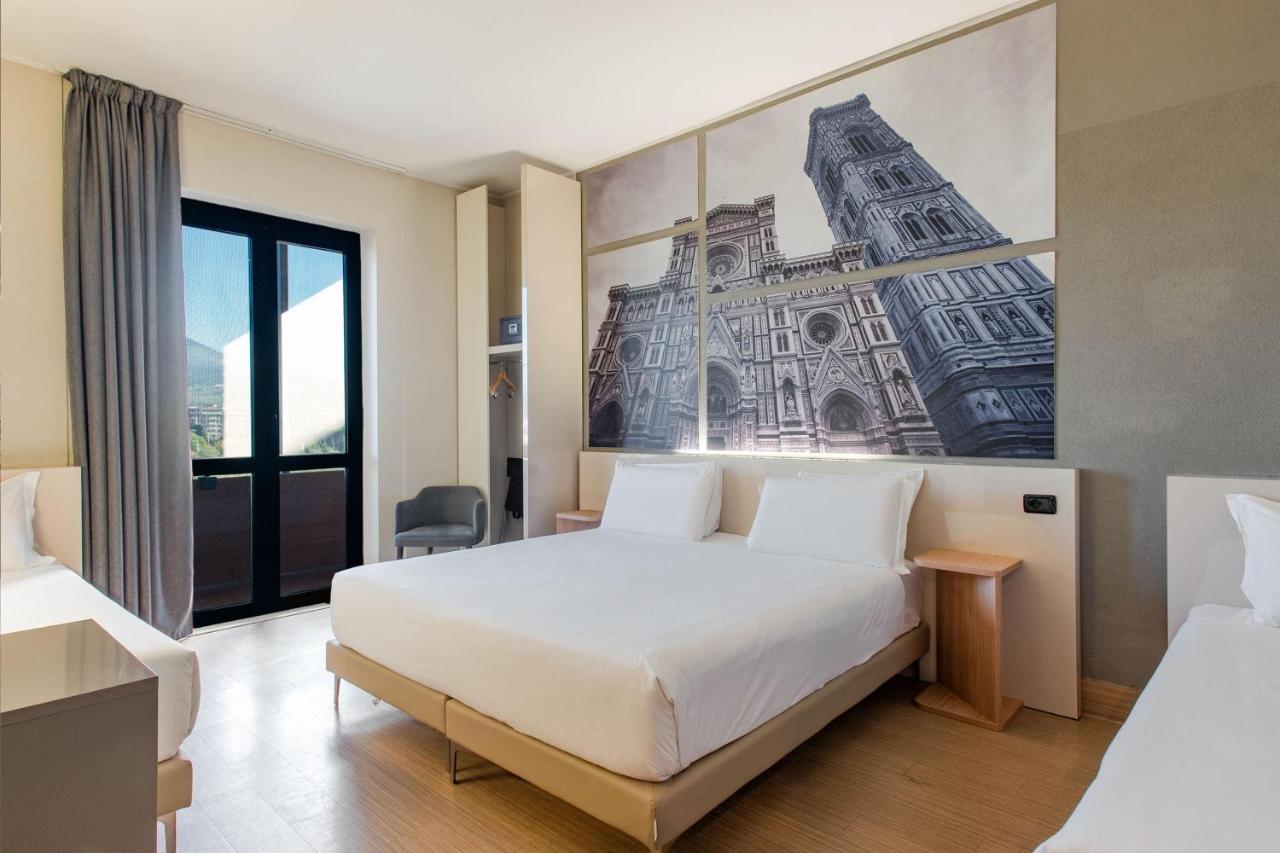 een hotelkamer met een bed en een schilderij aan de muur bij B&B Hotel Firenze Nuovo Palazzo Di Giustizia in Florence