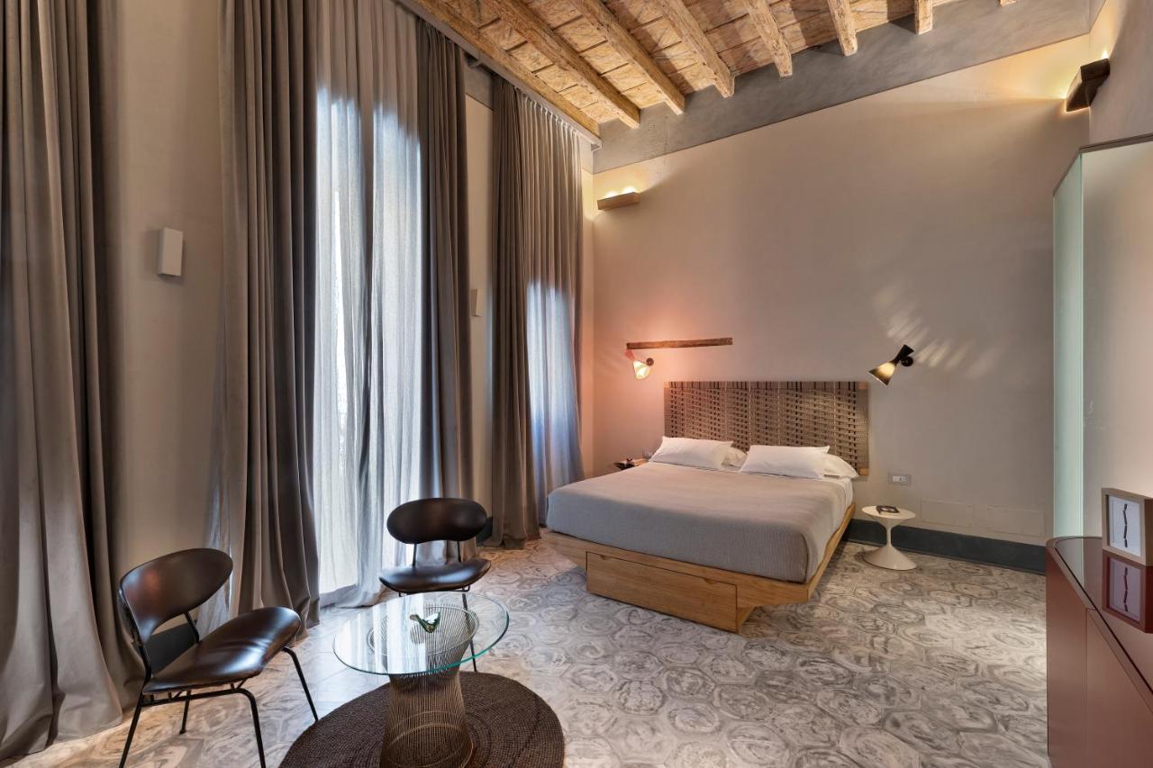 een slaapkamer met een bed, een tafel en stoelen bij Palazzo Calò in Bari
