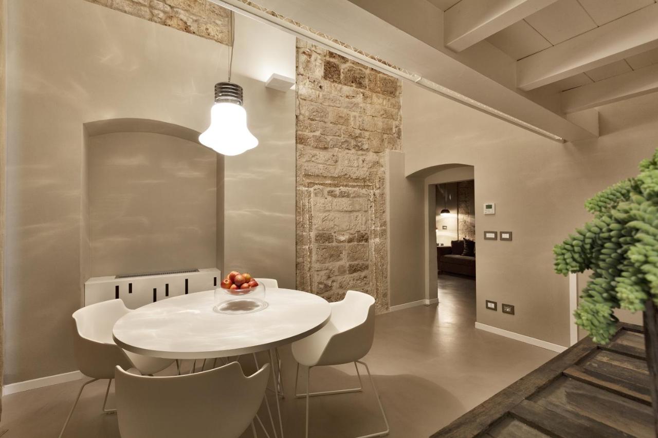 een eetkamer met een witte tafel en stoelen bij Palazzo Calò in Bari