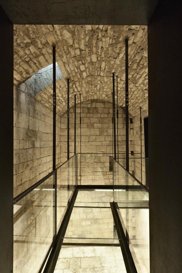 een glazen trap in een gebouw met een stenen muur bij Palazzo Calò in Bari