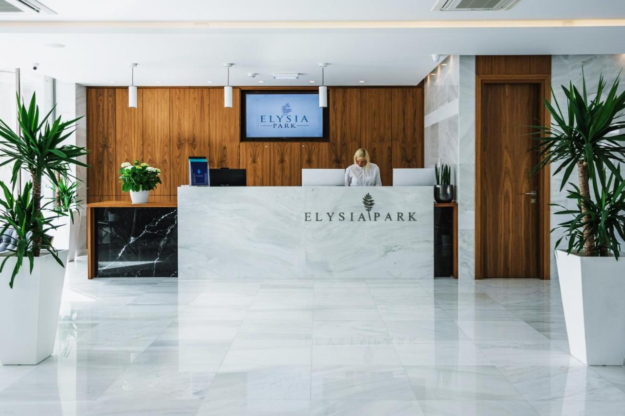 een vrouw die aan een bureau in een lobby staat bij Elysia Park in Paphos City +115 foto's