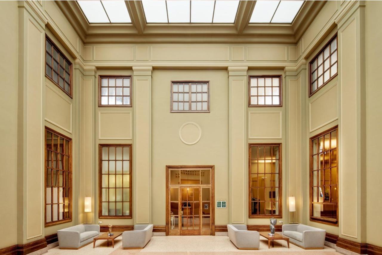 een grote lobby met stoelen en tafels en ramen bij Sercotel Arrahona Sabadell in Sabadell