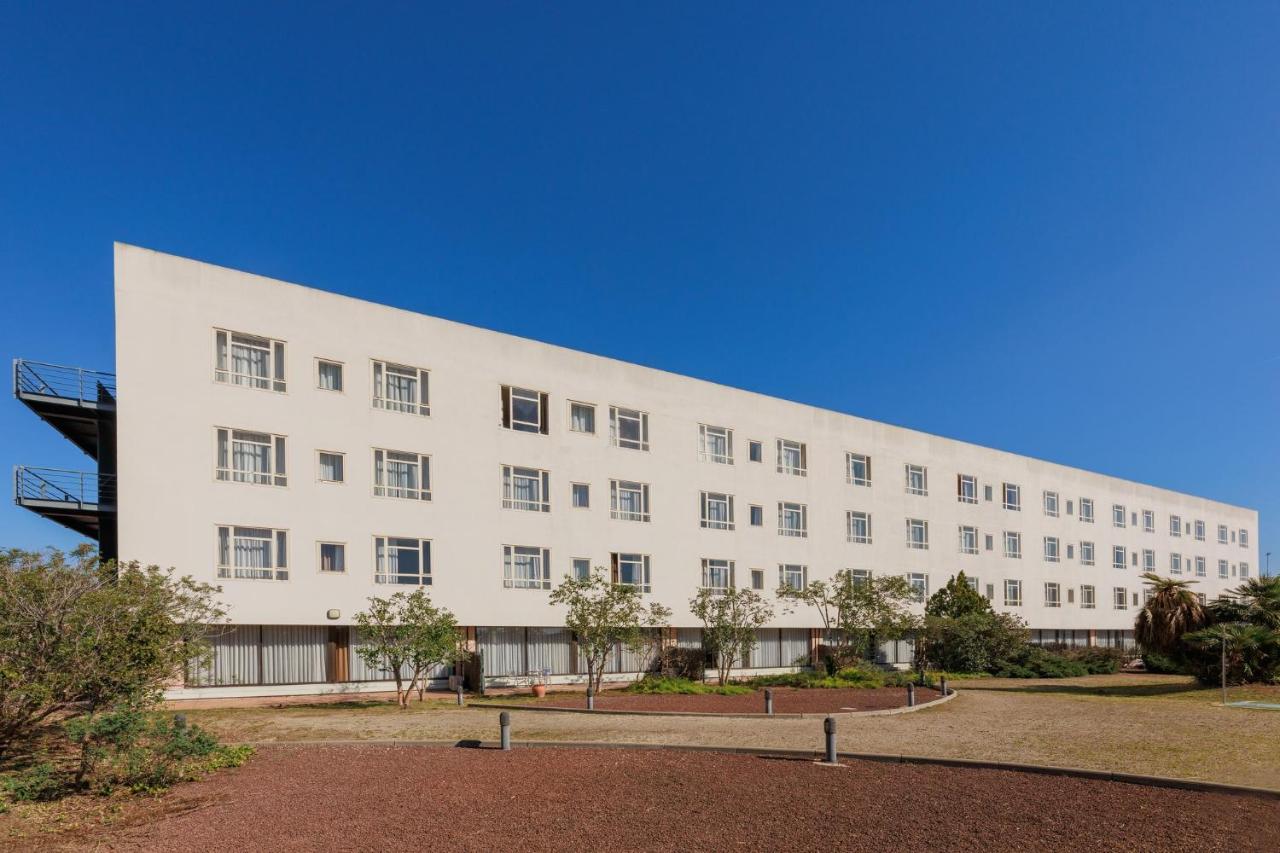 een groot wit gebouw met bomen ervoor bij Sercotel Arrahona Sabadell in Sabadell