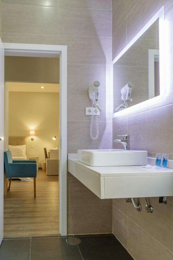een badkamer met een wastafel en een woonkamer bij Porto Domus Hotel in Porto