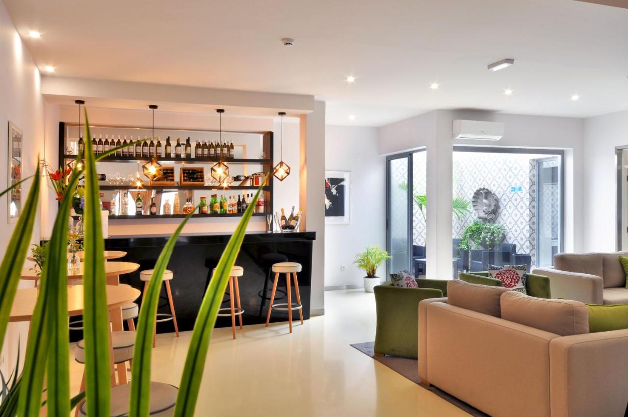 een woonkamer met een bar en wat planten bij Porto Domus Hotel in Porto