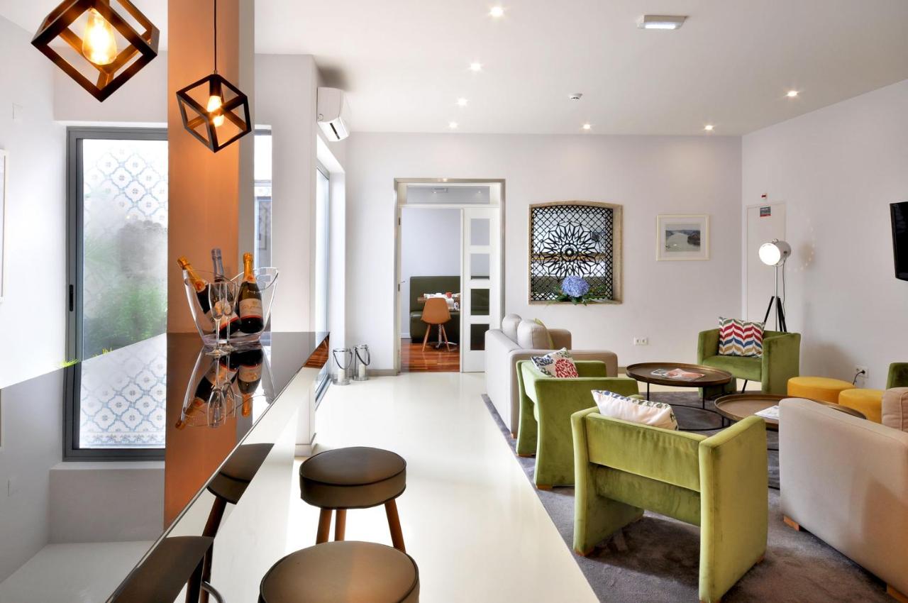een woonkamer met groen en wit meubilair bij Porto Domus Hotel in Porto