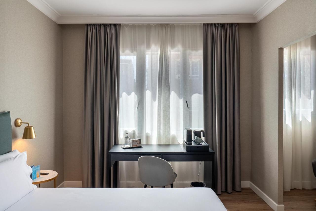 een hotelkamer met een bureau en een raam bij Tres Torres Atiram Hotel in Barcelona +59 foto's