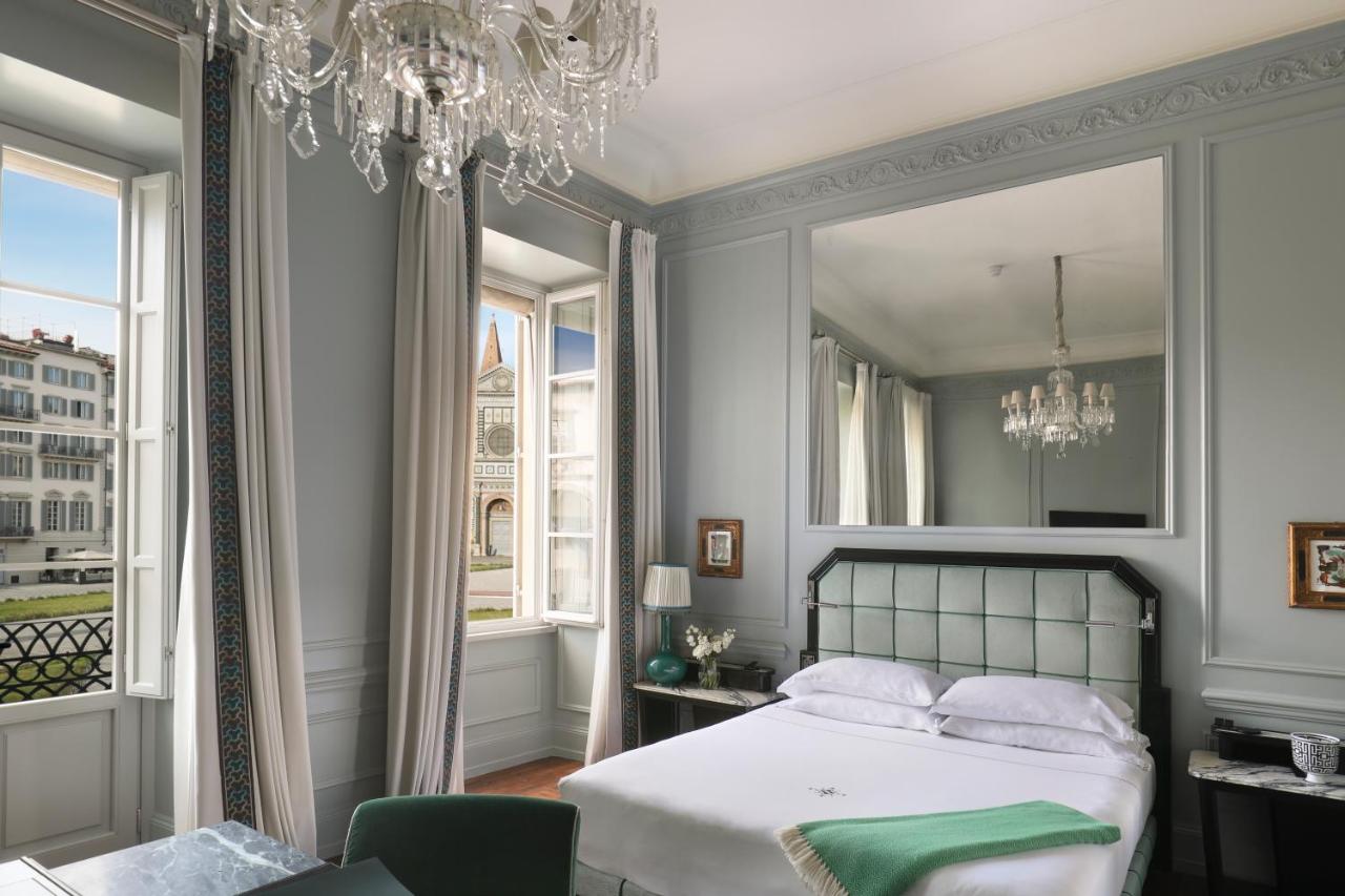 een slaapkamer met een bed en een kroonluchter bij The Place Firenze in Florence +45 foto's