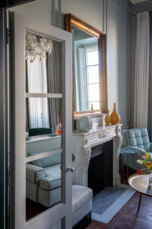 een woonkamer met een open haard en een spiegel bij The Place Firenze in Florence