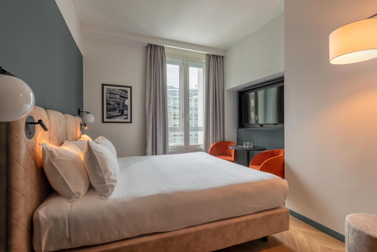 een slaapkamer met een bed en een bank bij Hotel Tocq in Milaan