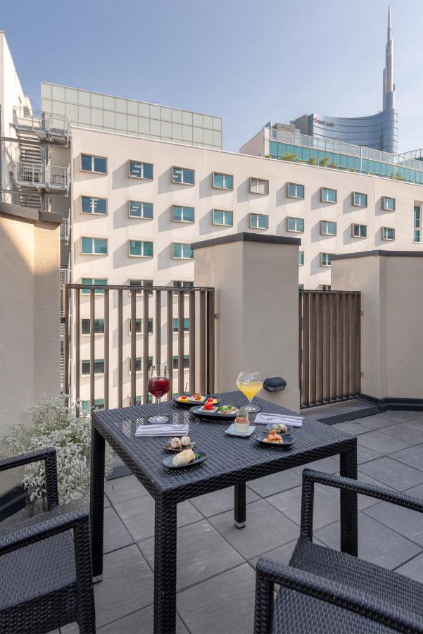 een zwarte tafel met eten en drinken op een balkon bij Hotel Tocq in Milaan