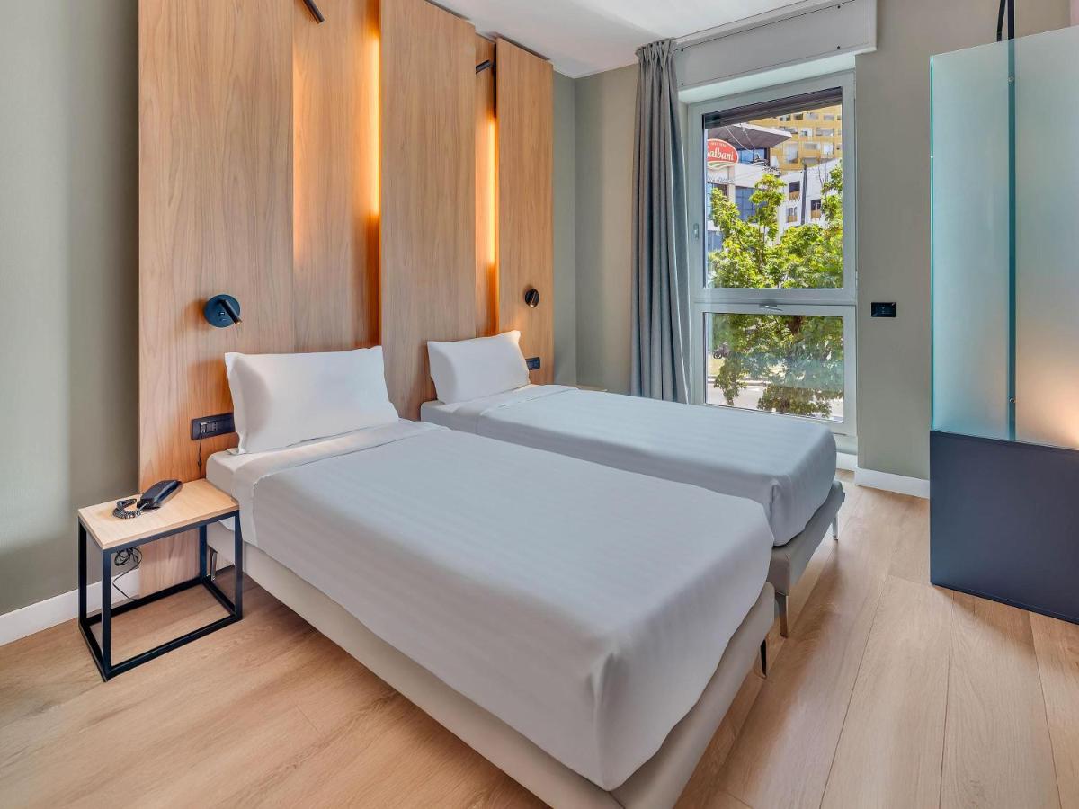 een slaapkamer met een groot wit bed en een televisie bij B&B HOTEL Milano Portello in Milaan