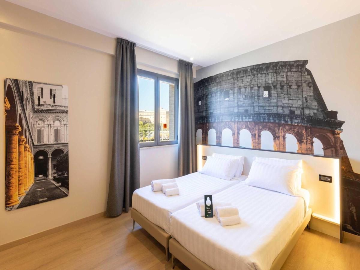 een slaapkamer met een groot bed en een schilderij aan de muur bij B&B Hotel Roma Tuscolana San Giovanni in Rome