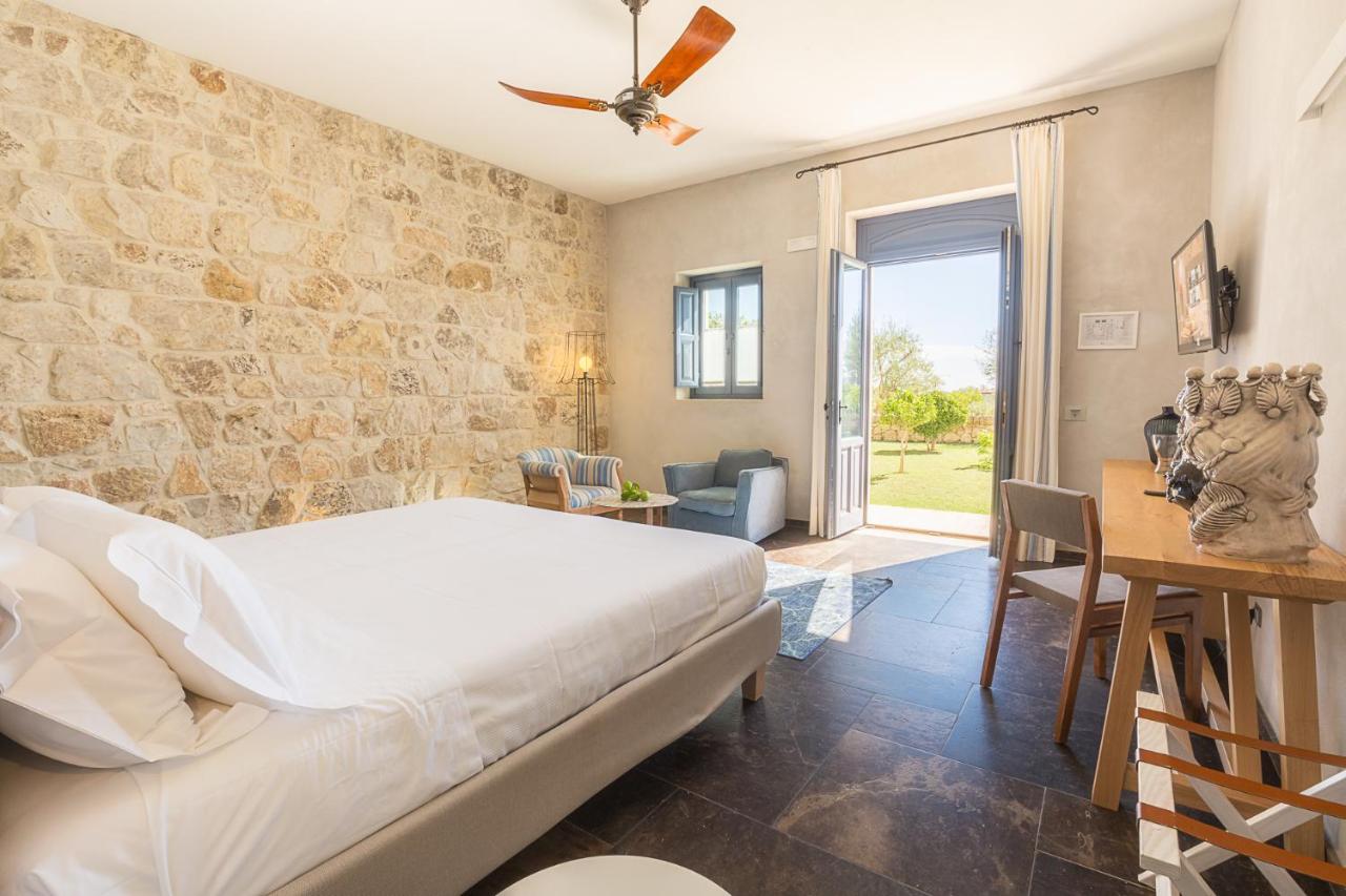 een slaapkamer met een bed en een stenen muur bij Masseria Della Volpe in Casale Modica +58 foto's