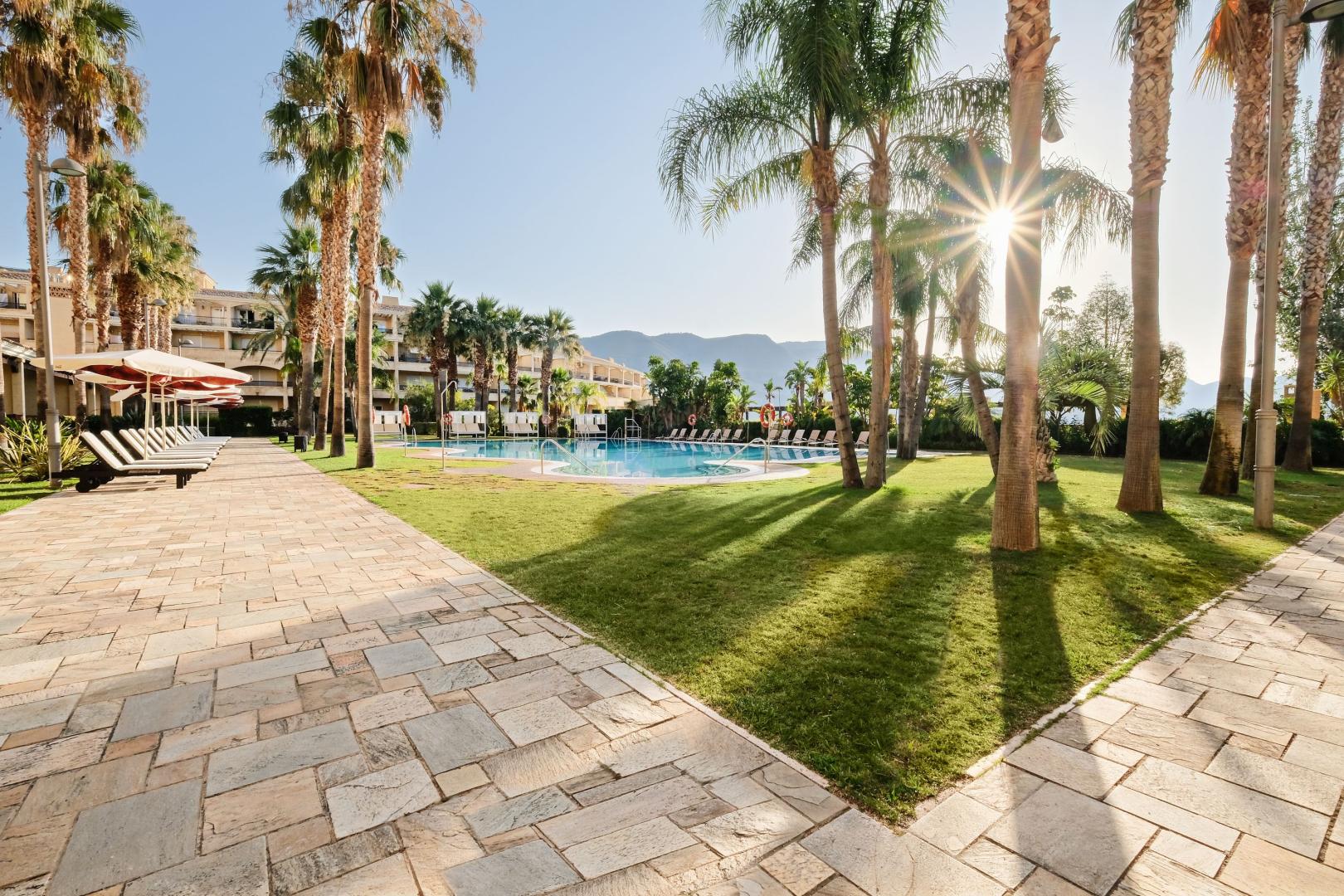 Zwembad omringd door palmbomen — Hotel Envía Almería Spa & Golf