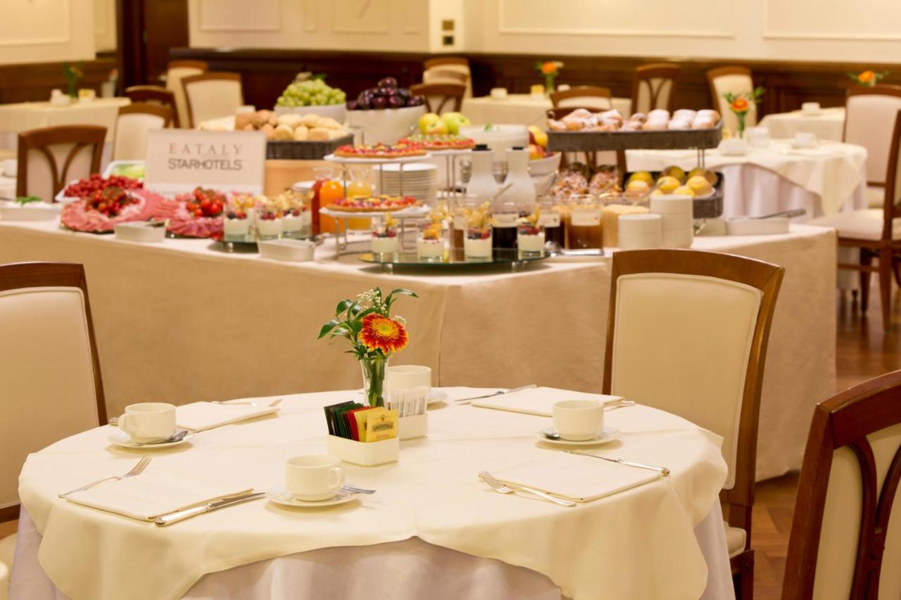 een eetkamer met tafels met witte tafelkleden en eten bij Starhotels Majestic in Turijn