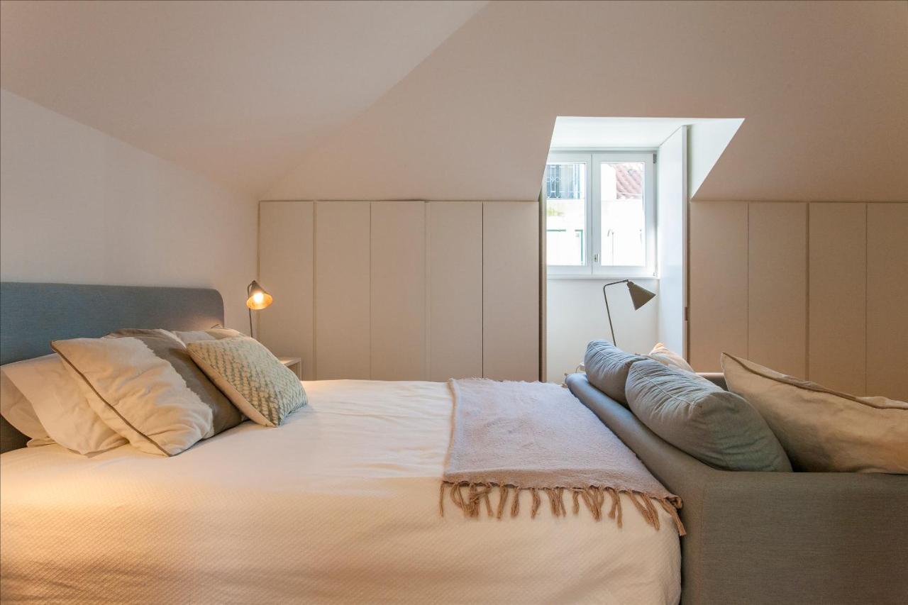 een slaapkamer met een groot wit bed met kussens bij Lisbon Five Stars Apartments Combro 77 in Lissabon
