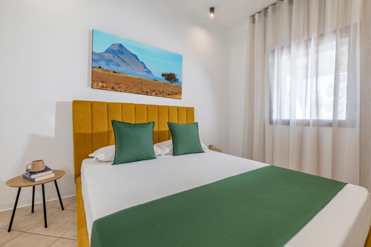 een slaapkamer met een groot bed met groene kussens bij Case Vacanza Loria in Castelluzzo
