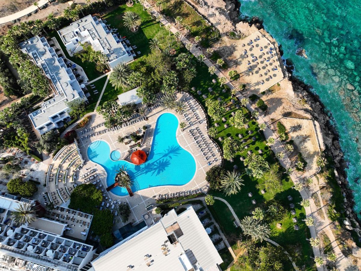 Een bovenaanzicht van een zwembad naast de oceaan. bij Azia Resort & Spa in Paphos City