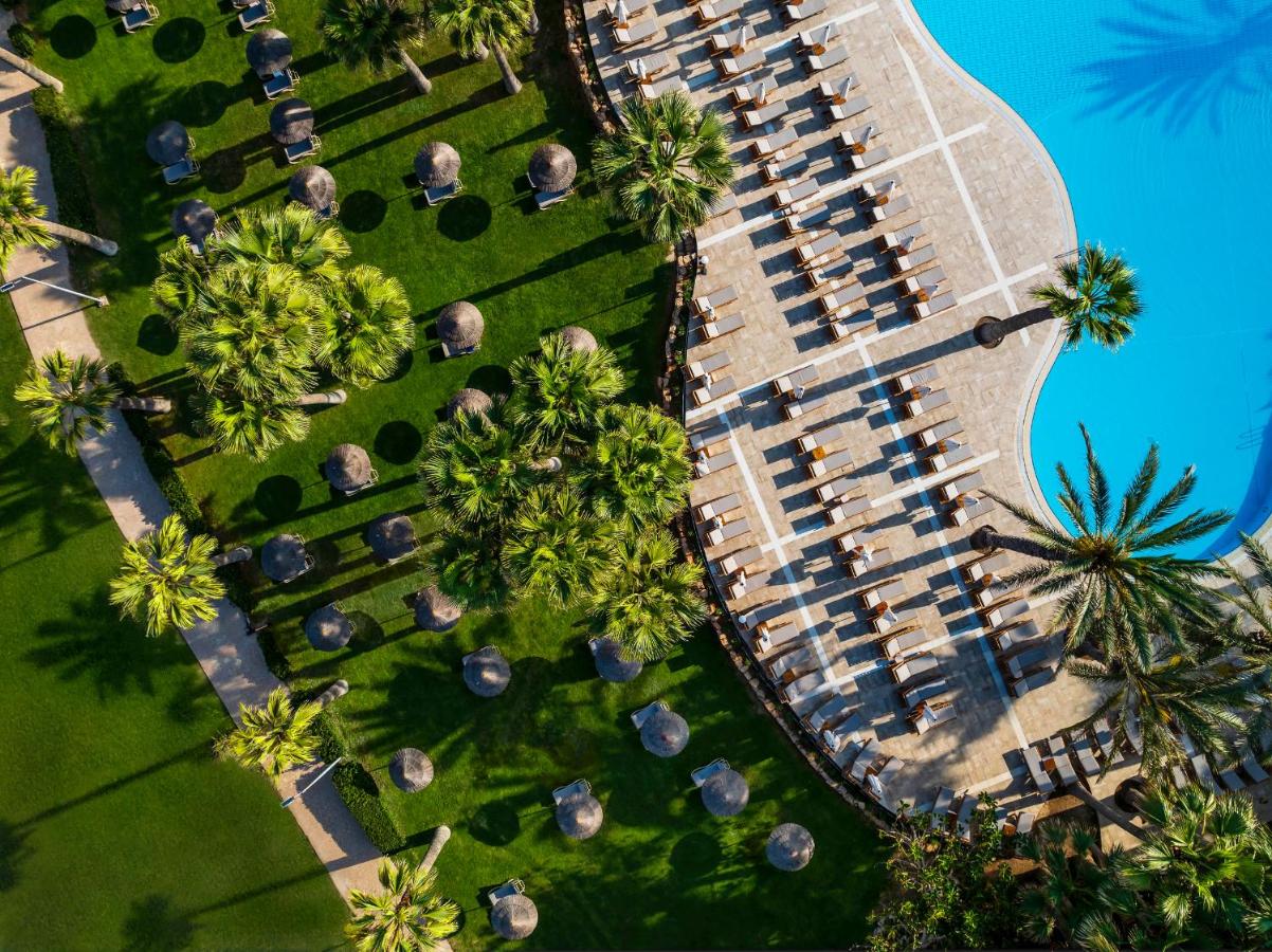 een bovenaanzicht van een parkeerplaats met palmbomen bij Azia Resort & Spa in Paphos City