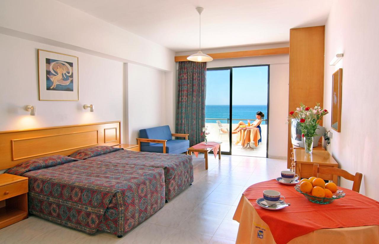 een hotelkamer met een bed en een tafel met fruit erop. bij Corallia Beach Hotel Apartments in Coral Bay