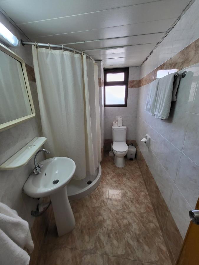 een badkamer met een wastafel, een toilet en een douche bij Corallia Beach Hotel Apartments in Coral Bay