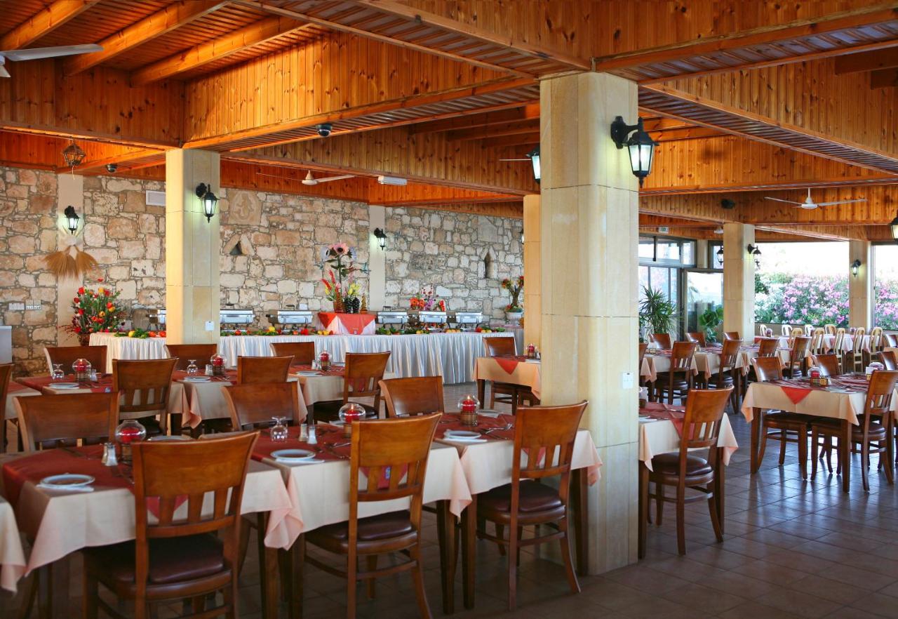 een eetzaal met tafels en stoelen in een gebouw bij Corallia Beach Hotel Apartments in Coral Bay