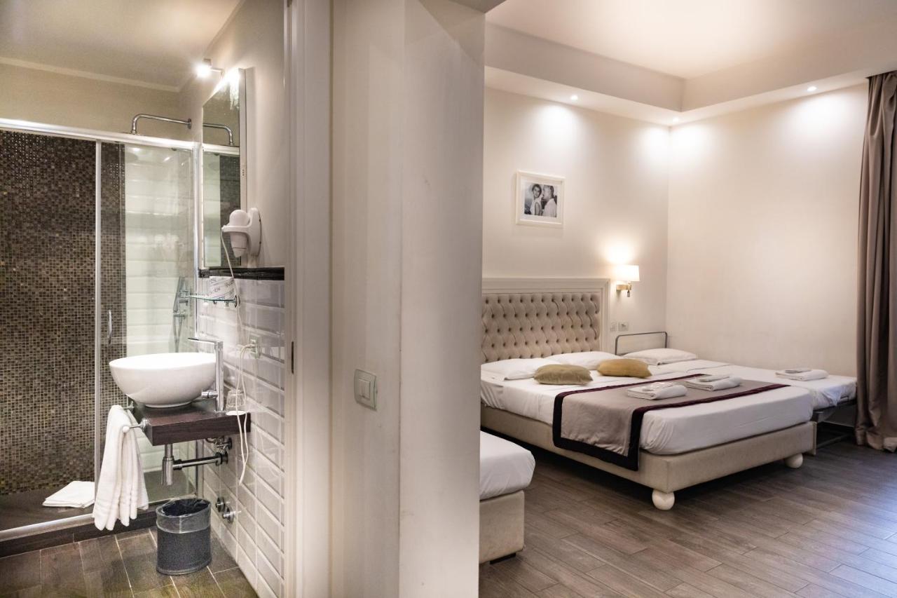 een slaapkamer met een bed en een badkamer met een wastafel bij Relais Monti in Rome