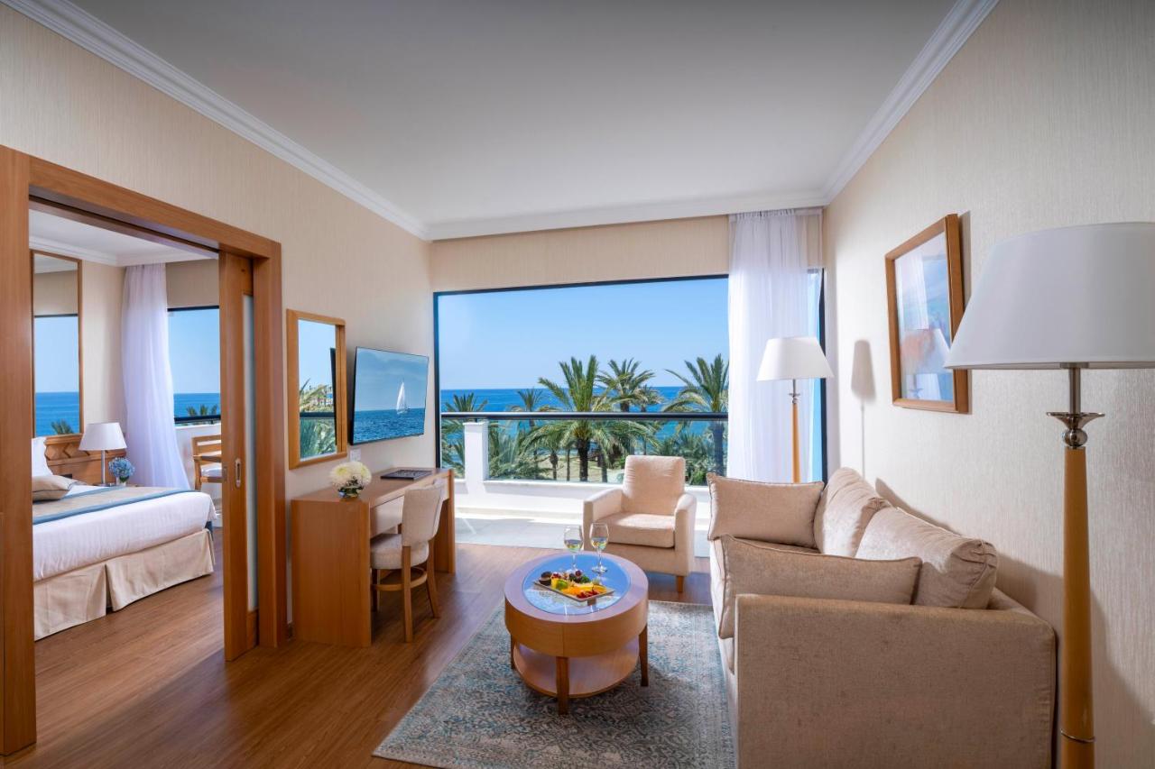 een woonkamer met een kamer die uitzicht biedt op de oceaan bij Constantinou Bros Asimina Suites Hotel in Paphos City