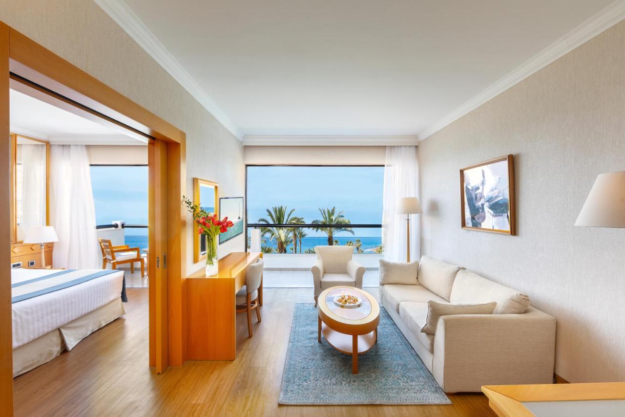 een woonkamer met een bank, een bed en een tafel bij Constantinou Bros Asimina Suites Hotel in Paphos City