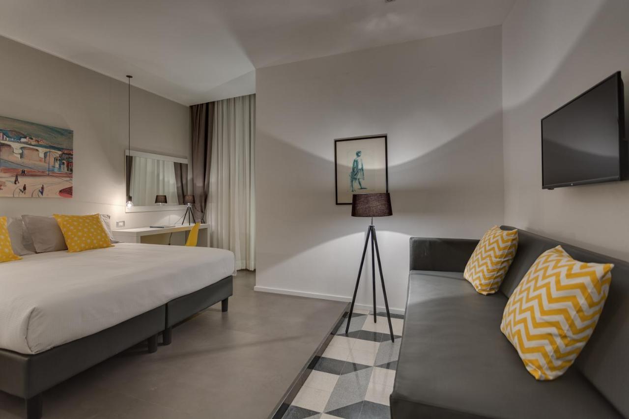 een hotelkamer met een bed en een bank bij Navona Theatre Hotel in Rome