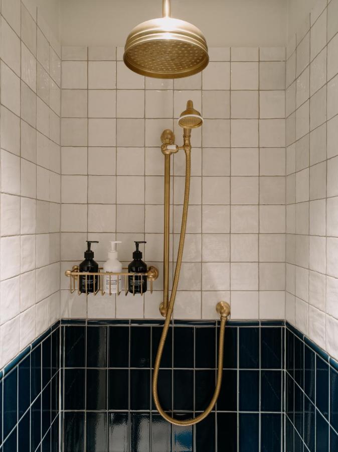 een douche in een badkamer met blauw-witte tegels bij The Hoxton, Florence in Florence