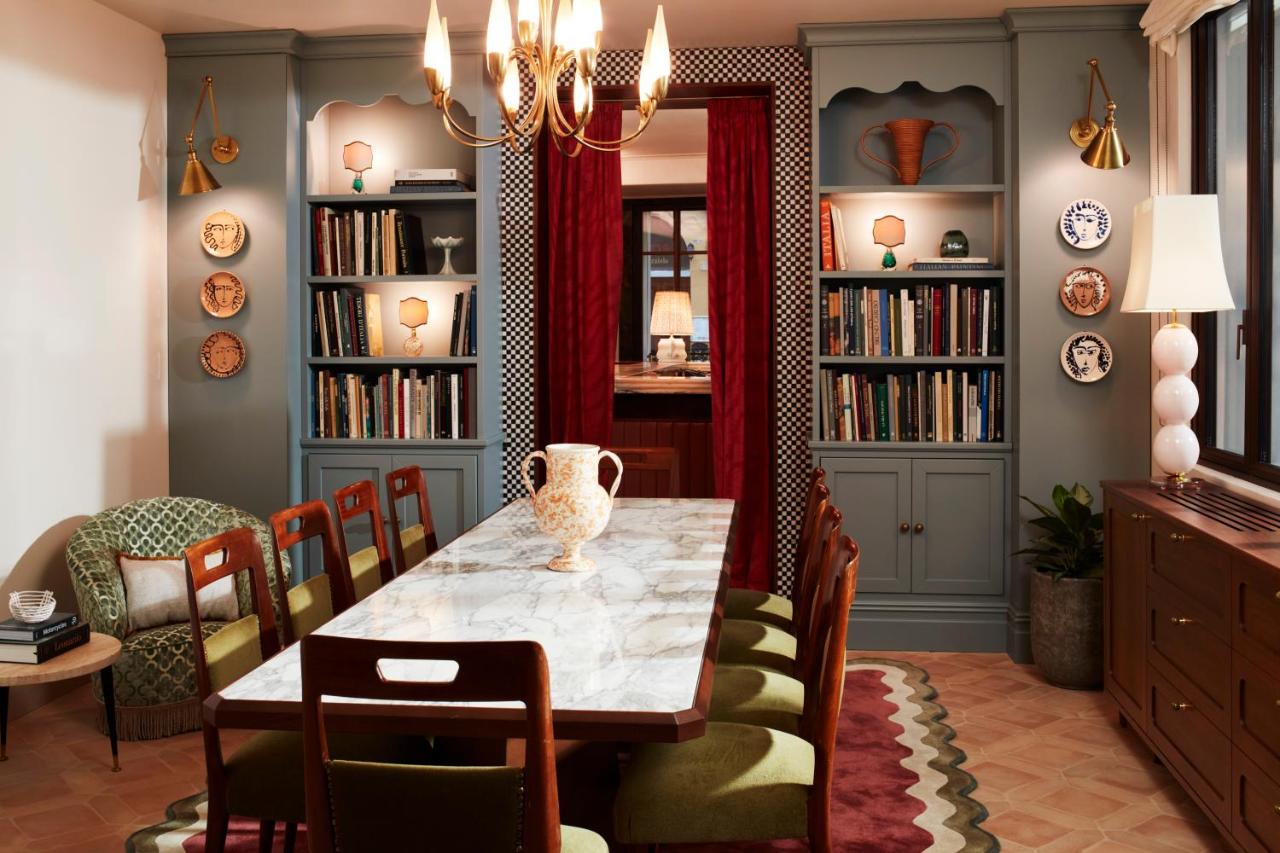een eetkamer met een tafel, stoelen en boekenkasten bij The Hoxton, Florence in Florence