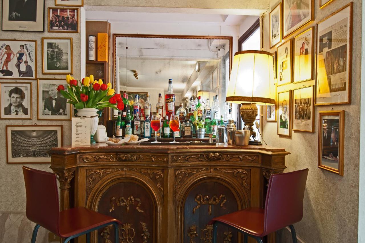 een bar met een heleboel flessen erop bij Hotel La Fenice et Des Artistes in Venetië
