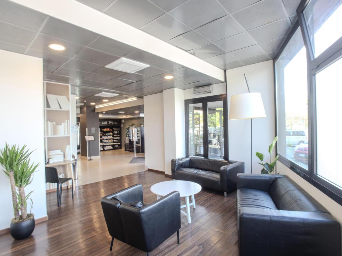 een lobby met banken, een tafel en stoelen bij B&B Hotel Firenze Novoli in Florence