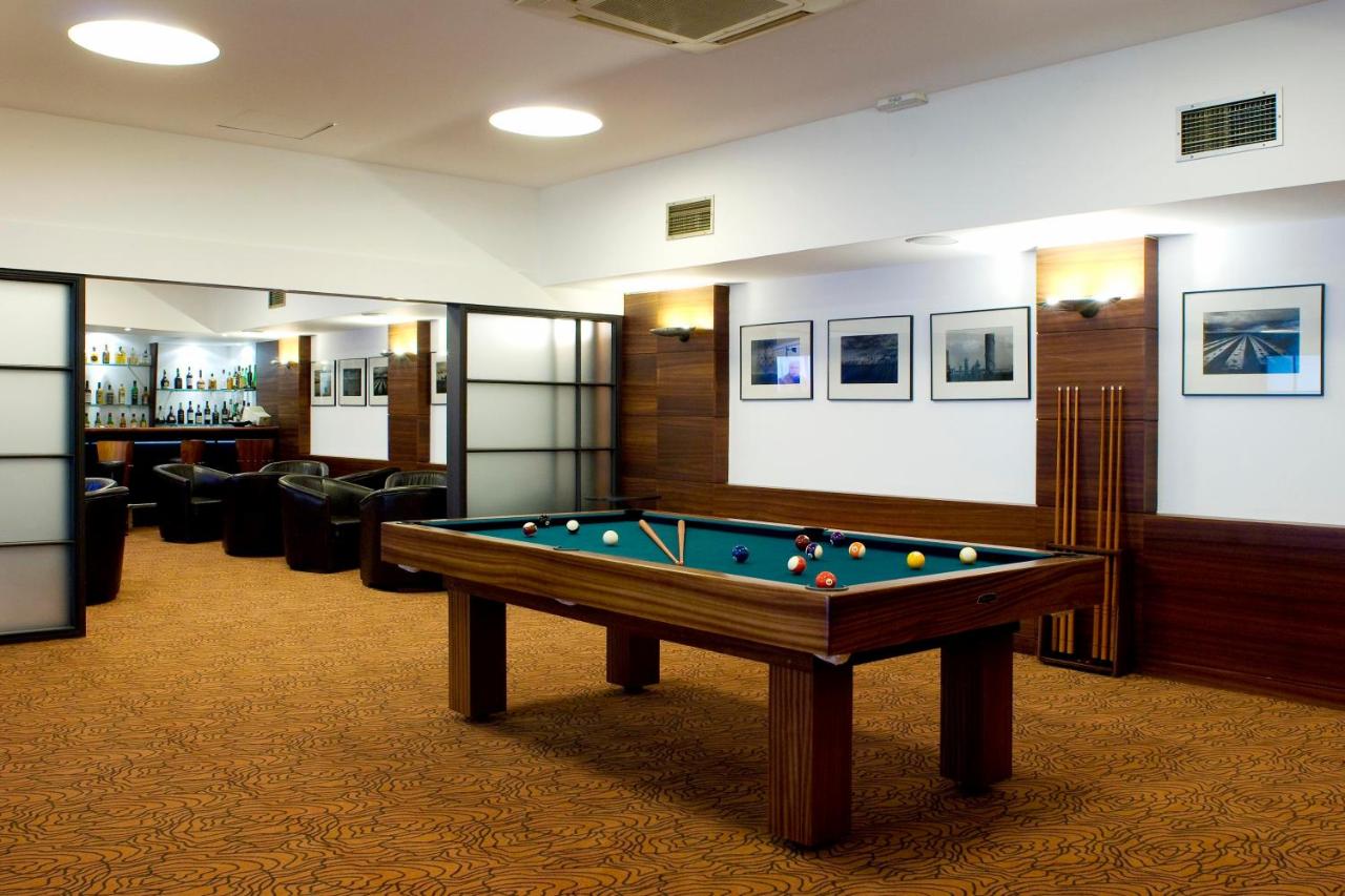 een biljartkamer met een pooltafel en stoelen bij Leziria Parque Hotel in Vila Franca de Xira