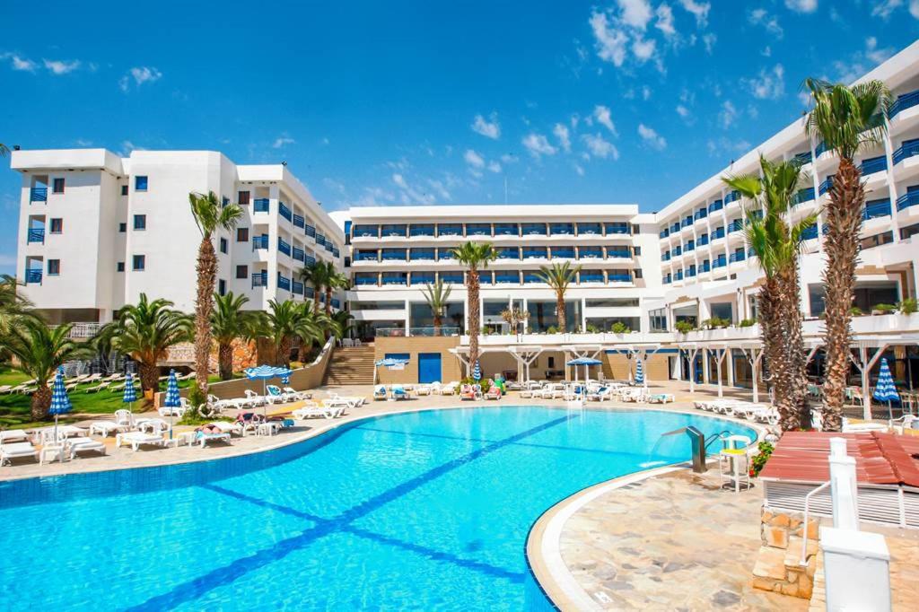 een resort met een groot zwembad voor een gebouw bij Ascos Coral Beach Hotel in Coral Bay