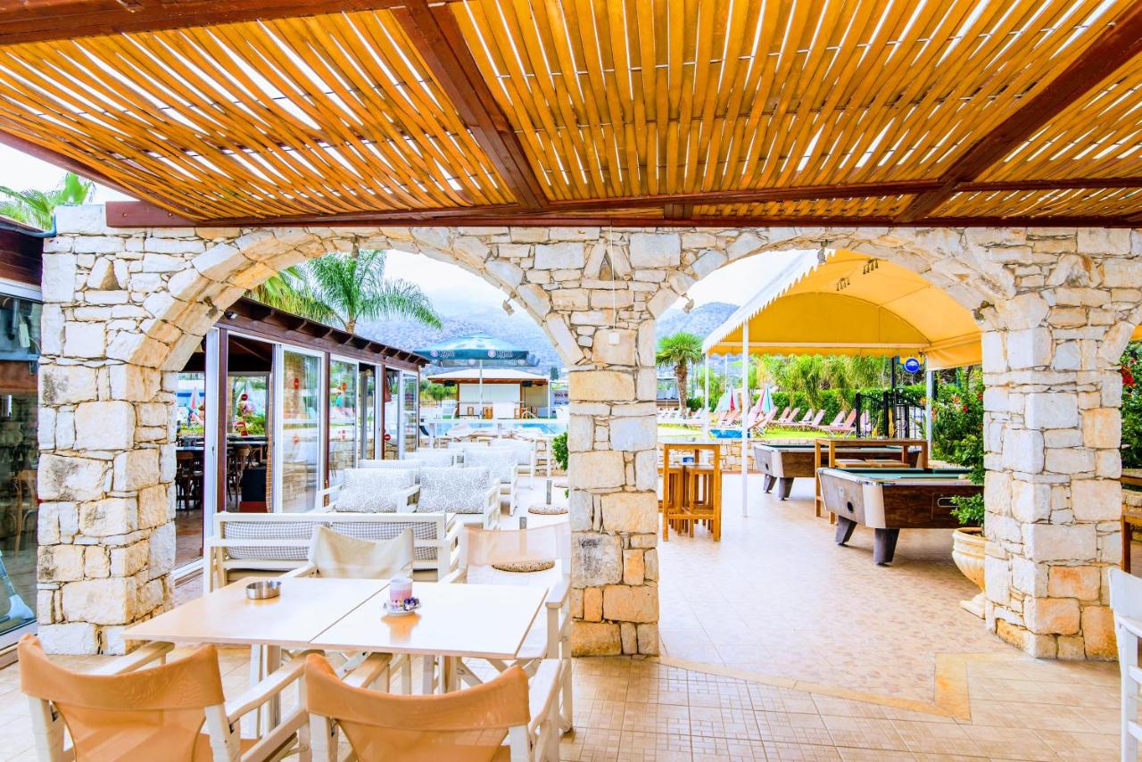 een terras buiten met tafels en stoelen bij Yiannis Manos Hotel Resort in Malia