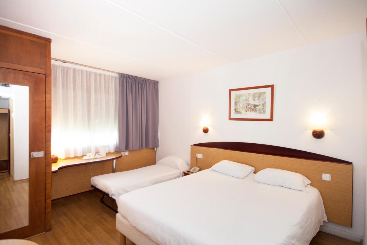een hotelkamer met twee bedden en een bureau bij Travelodge Barcelona del Vallés in Barbera del Valles
