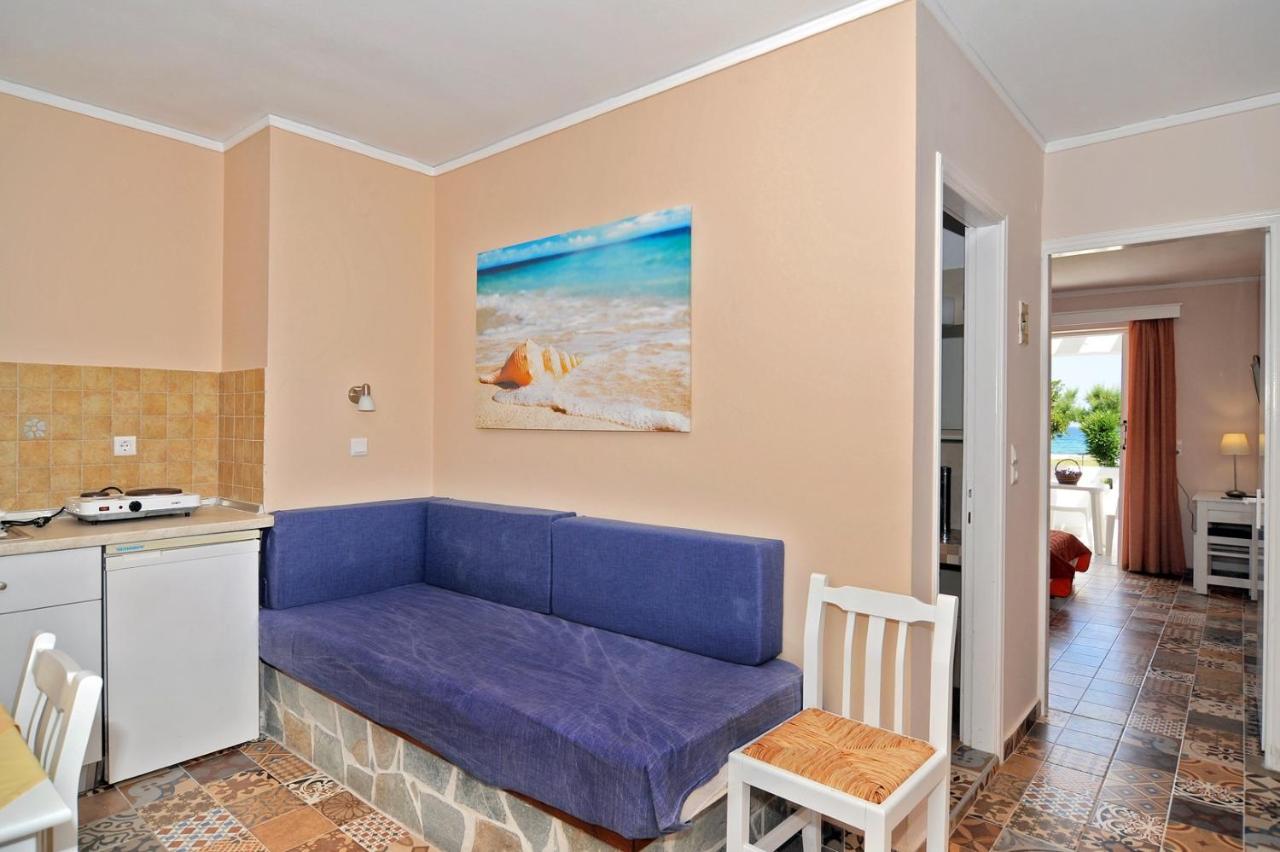 een woonkamer met een blauwe bank in een keuken bij Byron Apartments in Tigaki