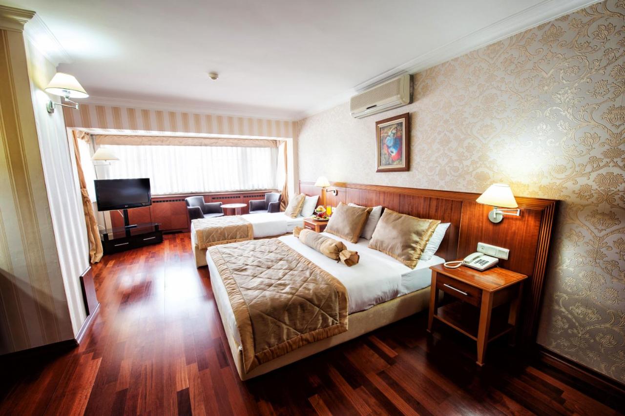een hotelkamer met een bed waarop een teddybeer ligt bij Hotel Centrum Istanbul in Istanbul