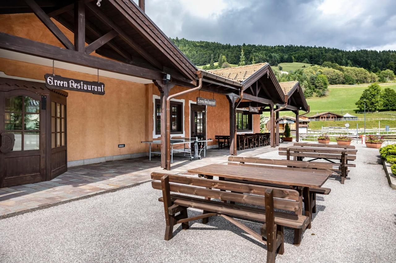 een groep banken buiten een gebouw bij Golf Hotel in Folgaria