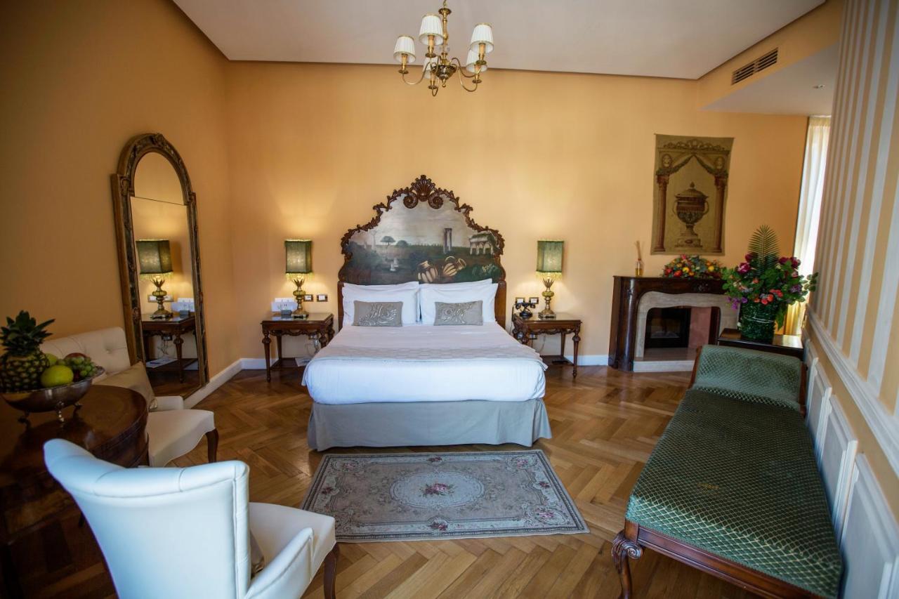 een slaapkamer met een groot bed en een open haard bij Royal Suite Trinità Dei Monti in Rome