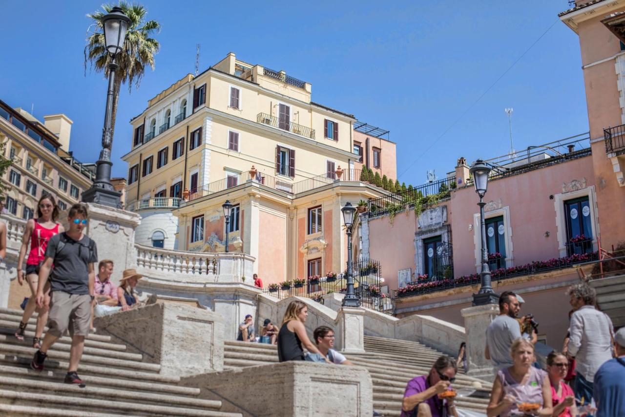 een groep mensen die op de trappen van een gebouw zitten bij Royal Suite Trinità Dei Monti in Rome