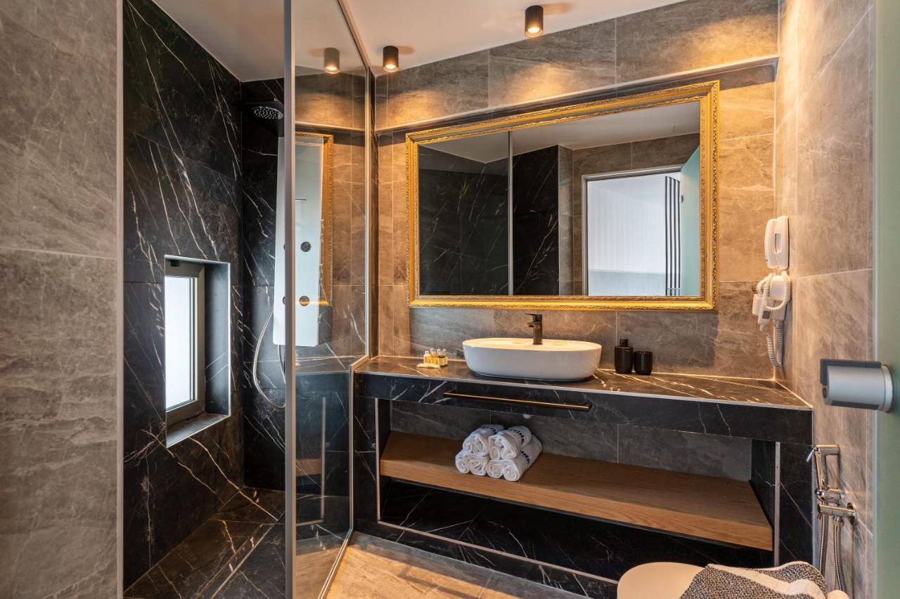 een badkamer met een wastafel en een spiegel bij Delfina Boutique Hotel in Georgioupolis
