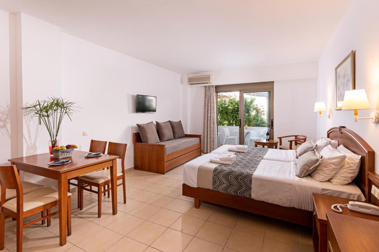 een hotelkamer met een bed en een eetkamer bij Delfina Boutique Hotel in Georgioupolis