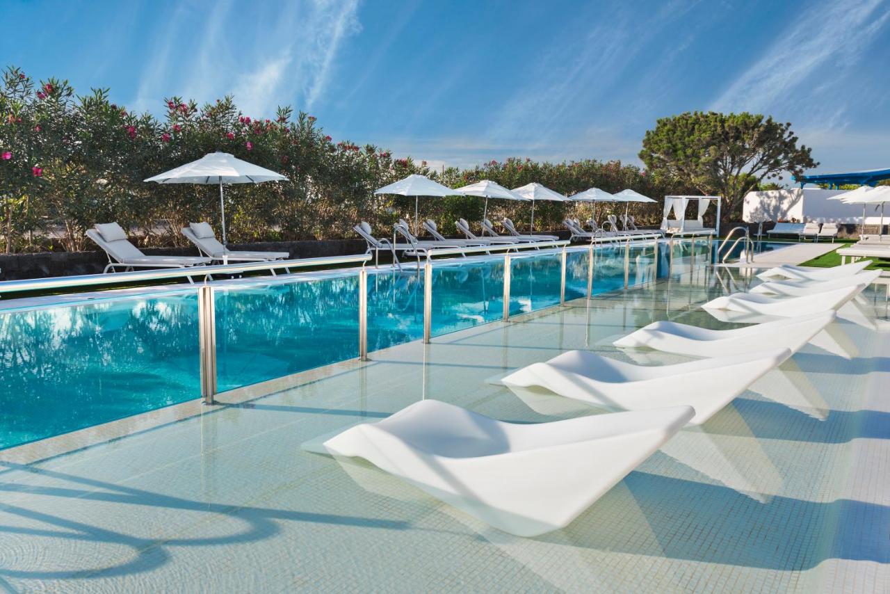 een rij witte ligstoelen en een zwembad bij Elba Premium Suites - Adults Only in Playa Blanca