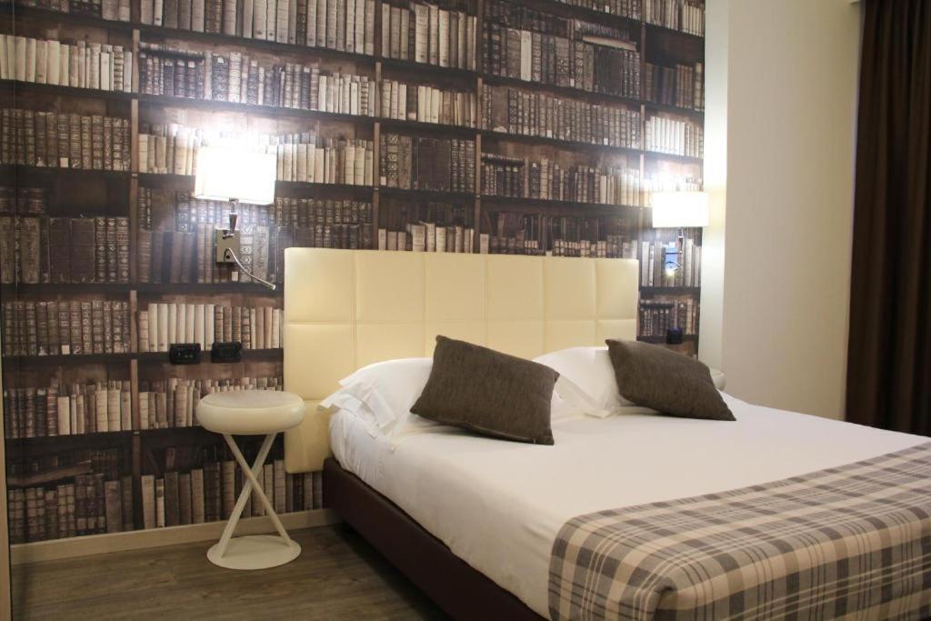 een slaapkamer met een bed en een boekenwand bij Duomo Hotel & Apartments in Milaan